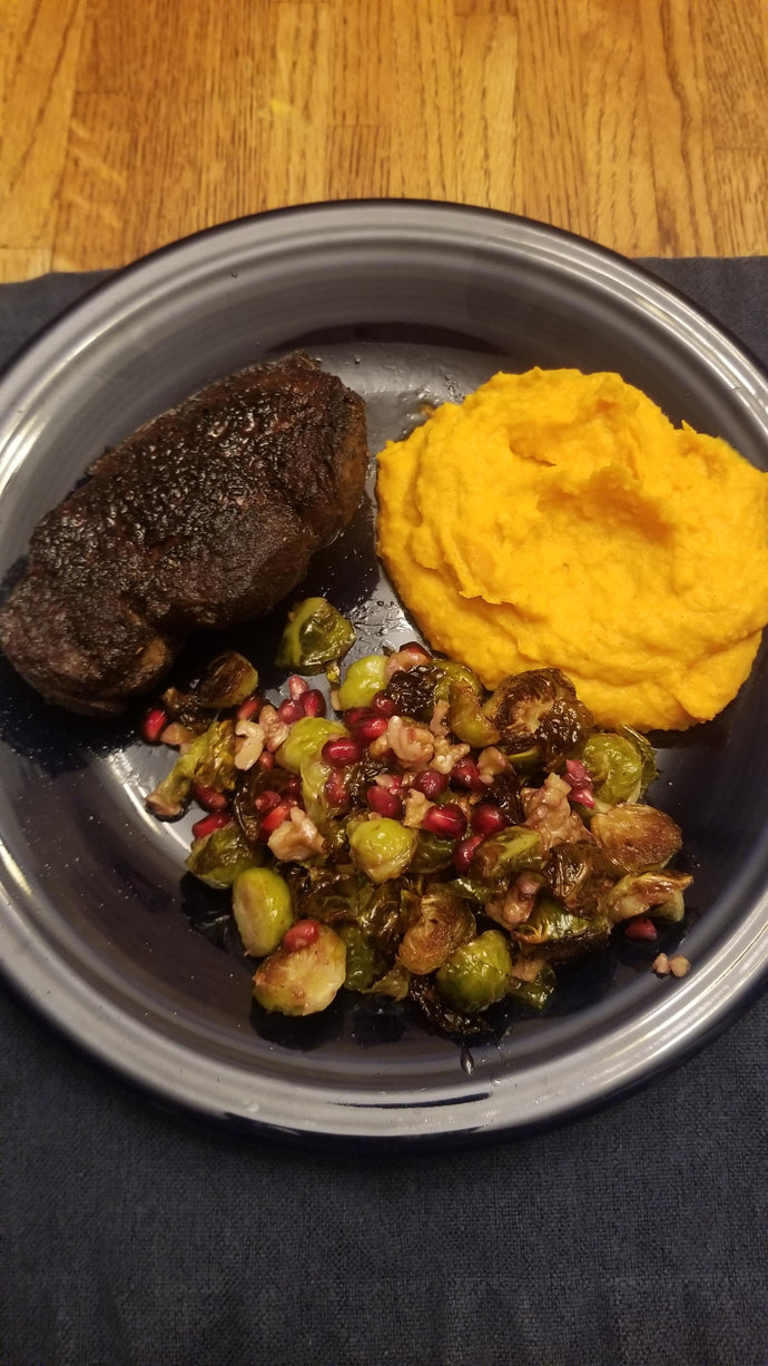 Coffee-rubbed filet mignon, vanilla bean-whipped sweet potatoes, and Brussels sprouts with toasted walnuts and pomegranate seeds
