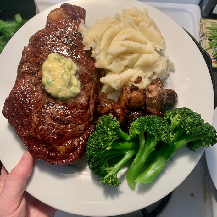 Topped off a great day with medium rare ribeyes with compound garlic-herb butter, steamed broccoli, mash, and garlicky mushrooms.