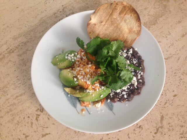Eggs in salsa roja with refryed beans and avocado.