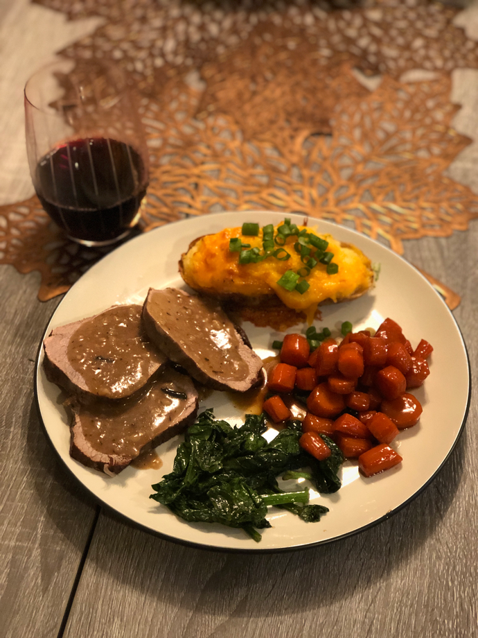 Stove top Pot Roast with gravy, twice baked potato, spinach and glazed carrots.