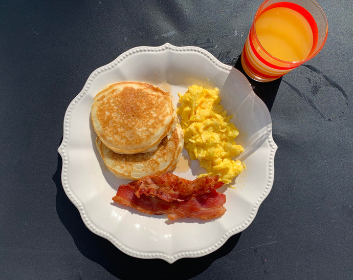 Fluffy pancakes, crispy bacon, scrambled eggs, and Natalies OJ.