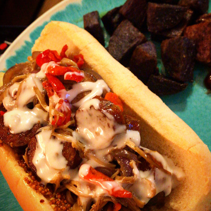 Andouille po boy with mad hatter peppers, red onion, enoki mushrooms, whole grain mustard, and horseradish sauce with roasted purple potatoes