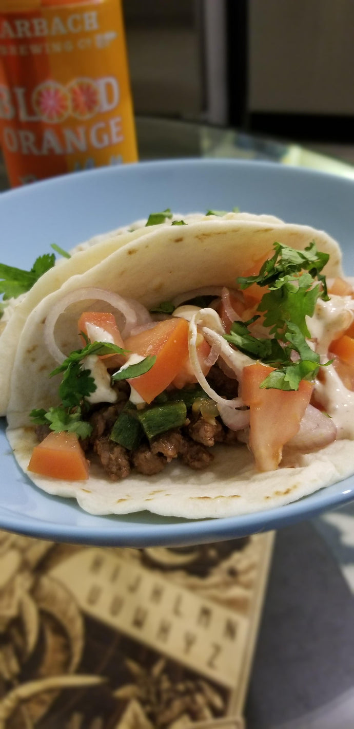 Steak tacos with pickled tomatoes and shallots, cream, poblanos and onions, and cilantro.